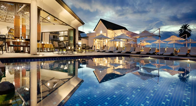 Hotel com piscina iluminada durante a noite